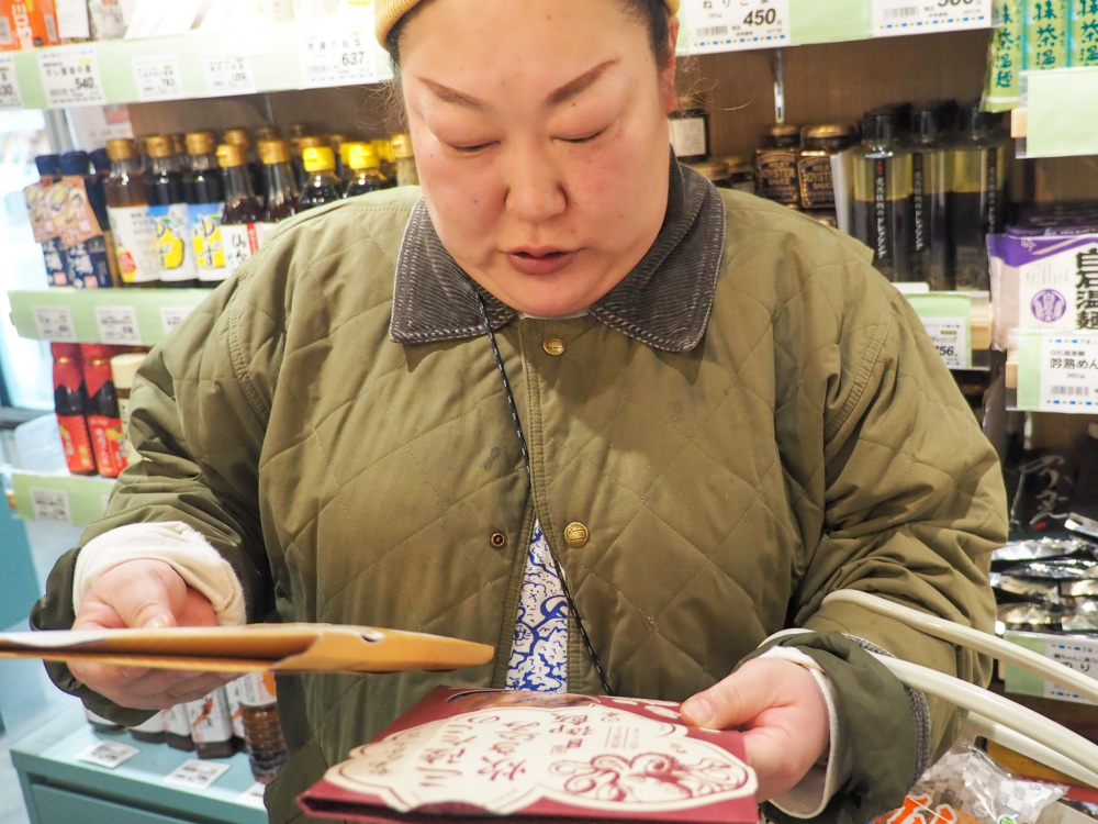 炊き込みご飯の素を見比べ「どっちにしよう……」と迷うハプさん。結局、どちらもお買い上げ