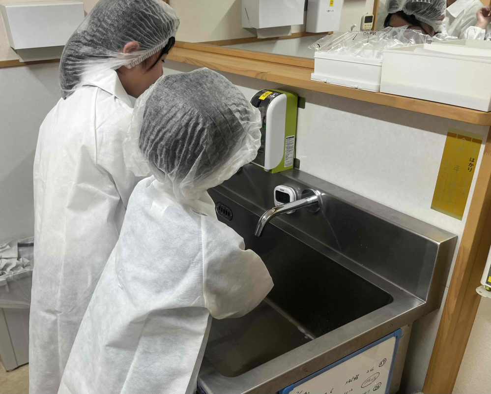 工場の手前でガウンを着て、帽子とマスクを装着。そして手洗い、手指消毒をして清潔に。